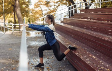 Sıska kadın bacak esnetme alıştırması yapıyor. Açık hava eğitimi. Sağlıklı yaşam tarzı kavramı
