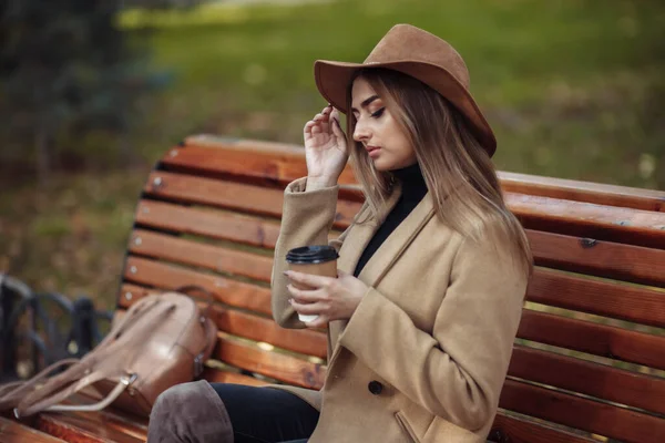 Mladá Atraktivní Žena Podzimním Oblečení Sedí Lavičce Pije Kávu Městském — Stock fotografie