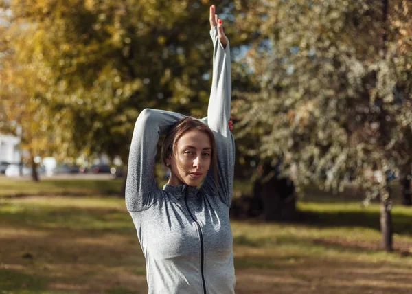 Egy Fiatal Sportruhás Bemelegít Őszi Parkban Nyújtott Kézzel Edzés Előtt — Stock Fotó