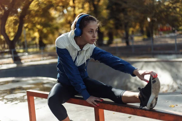Fit Szczupła Kobieta Odzieży Sportowej Słuchawki Ćwiczące Rozciąganie Nóg Przed — Zdjęcie stockowe