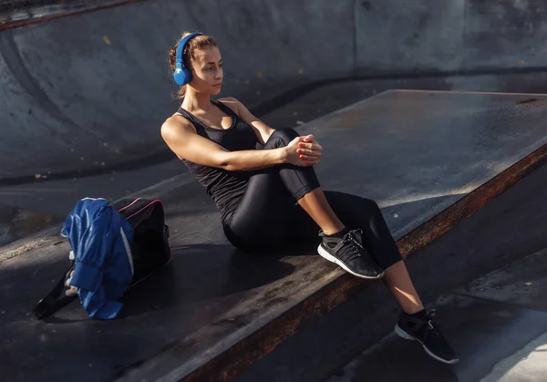 Spor Giyimli Çekici Bir Kadın Spor Salonunda Otururken Kulaklıkla Müzik — Stok fotoğraf