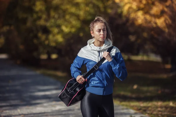 Pasująca Szczupła Kobieta Sportowym Stroju Torba Treningowa Ramieniu Spaceruje Jesiennym — Zdjęcie stockowe