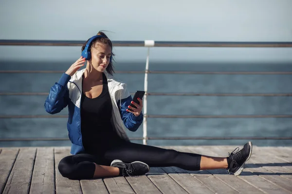 Relaxed Fit Vrouw Sportkleding Met Hoofdtelefoon Kiest Muziek Van Een — Stockfoto