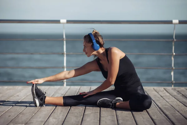 Slim Fit Vrouw Sportkleding Doen Stretching Benen Het Luisteren Naar — Stockfoto