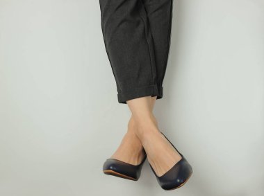 İş kadını düz konsept. Pantolon giymiş kadın bacakları ve beyaz arka planda topuklu klasik ayakkabılar. Üst Manzara. Güzellik ve moda stüdyosu