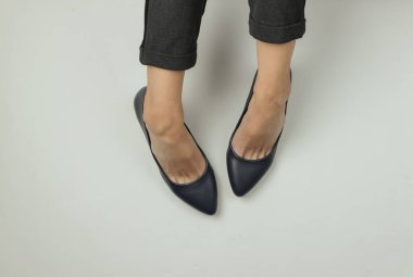 İş kadını düz konsept. Pantolon giymiş kadın bacakları ve beyaz arka planda topuklu klasik ayakkabılar. Üst Manzara. Güzellik ve moda stüdyosu