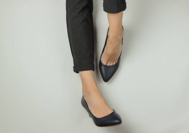 İş kadını düz konsept. Pantolon giymiş kadın bacakları ve beyaz arka planda topuklu klasik ayakkabılar. Üst Manzara. Güzellik ve moda stüdyosu