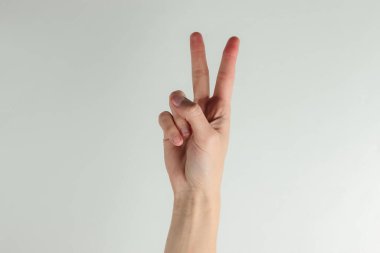 Kadın eli beyaz arkaplanda V işareti gösterir
