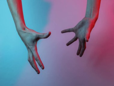 Kadın eli. Neon mavi-kırmızı ışık. Mistik ışık, Cadılar Bayramı teması. Retro dalga 80 'ler