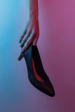 Kadın eli klasik yüksek topuklu ayakkabı. Yaratıcı pop sanatının pembe neon rengi. Moda eğilimli aydınlatma. Gece lambası