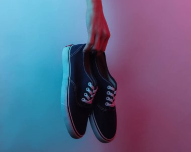 Kadın el ele tutuşan ayakkabılar. Yaratıcı pop sanatının pembe neon rengi. Moda eğilimli aydınlatma. Gece lambası