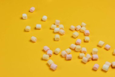 Sarı arka planda bir sürü mini marşmelov var. Pop sanat