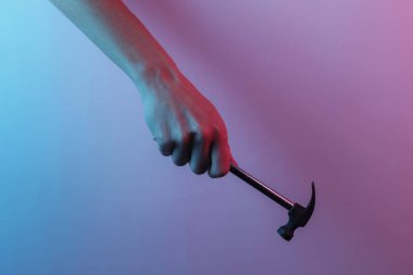 Eli çekiç tutuyor. Yaratıcı pop sanatının pembe neon rengi. Moda eğilimli aydınlatma. Gece lambası