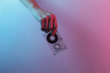 Retro dalga 80 'ler. El ele tutuşan ses kasedi. Yaratıcı pop sanatının pembe neon rengi. Moda eğilimli aydınlatma. Gece lambası