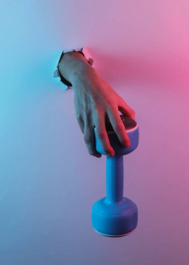 Elleri dambılı yırtılmış delikten tutuyor. Yaratıcı pop sanatının pembe neon rengi. Moda eğilimli aydınlatma. Gece lambası