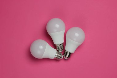 Pembe arka planda üç LED ampul. Üst görünüm