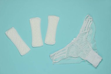 Mavi pastel arka planda kadın donu ve pedleri. Kadın hijyeni konsepti. Kritik günler, adet günleri. Üst Manzara. Düz yatıyordu