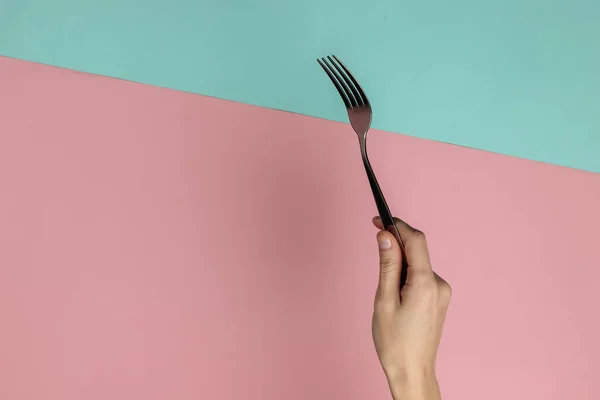 Mano Femenina Sostiene Tenedor Sobre Fondo Pastel Azul Rosado Vista — Foto de Stock