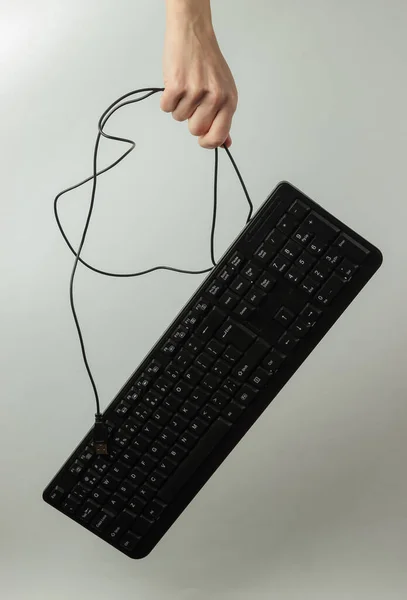 Beyaz Bir Arkaplanda Kabloyla Bağlı Olmayan Bir Klavye Tutar — Stok fotoğraf