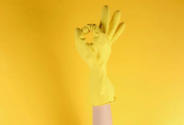 清洁房屋的概念 女用手戴着黄色橡胶手套清洁 在黄色背景下摆出姿势还行 — 图库照片