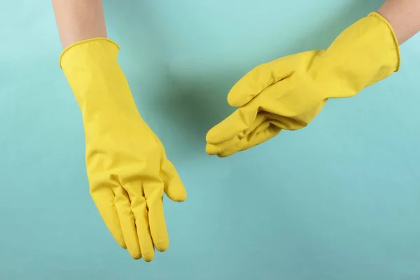 Vrouwelijke Handen Gele Rubberen Handschoenen Blauwe Studioachtergrond Huisschoonmaakconcept Ninja Thema — Stockfoto