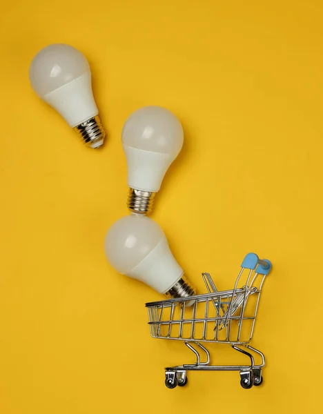 Three Led Light Bulbs Shopping Cart Yellow Background Top View — Stock Photo, Image