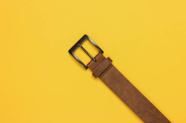 Sarı arka planda kahverengi deri kemer.