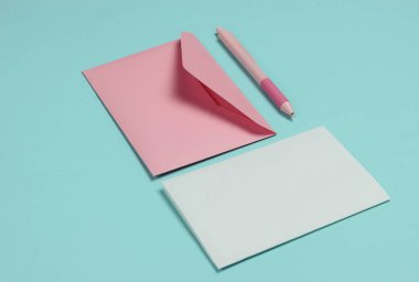 Zarfta mavi pastel arka planda bir mektup ve kalem var. Sevgililer Günü, düğün ya da doğum günü