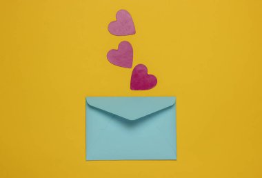 Sarı arka planda dekoratif kalpler olan zarf. Sevgililer günü, düğün ya da doğum günü için düz yatış modeli. Üst görünüm