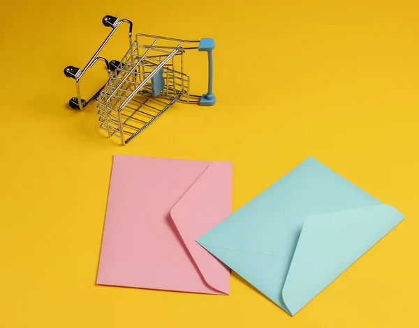 Rosa Azul Dois Envelopes Carrinho Compras Fundo Amarelo Mockup Para — Fotografia de Stock