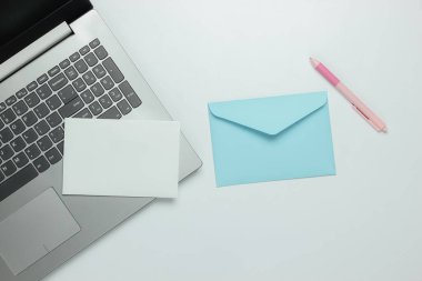 Laptop ve beyaz arkaplanda harf olan zarf. Sevgililer Günü. Üst görünüm