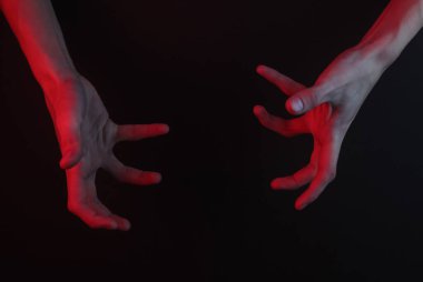 Siyah bir arka planda kadın elinin müthiş bir hareketi. Cadılar Bayramı konsepti Kırmızı neon ışık