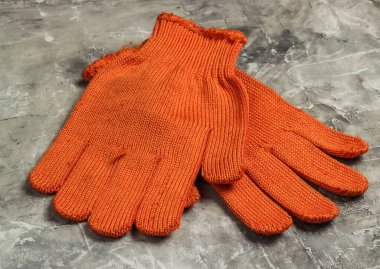 Gri beton arka planda turuncu iş eldivenleri