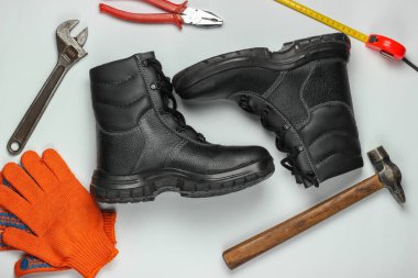 Farklı endüstriyel aletler ve aletlerle bembeyaz arka planda güvenlik ekipmanları olan düz bir kompozisyon. Üst görünüm