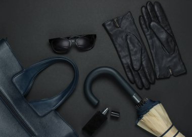 Siyah arka planda kadın moda aksesuarları. Köpük torbası, eldiven, şemsiye, güneş gözlüğü, parfüm şişesi. Üst görünüm