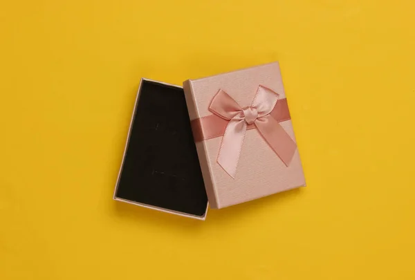 打开的礼品盒 黄色背景的蝴蝶结 圣诞节 生日或婚礼的作品集 顶部视图 — 图库照片