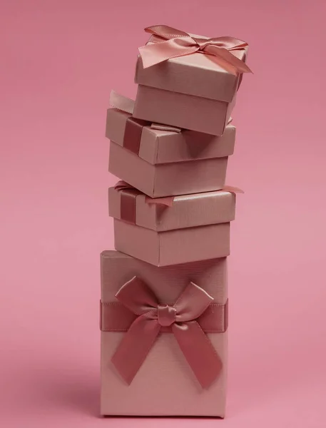 一堆堆带蝴蝶结的礼品盒 背景为粉红色 圣诞节 生日或婚礼的组成 — 图库照片
