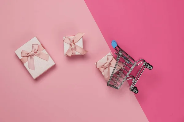 Carrinho Compras Caixas Presente Com Arcos Fundo Pastel Rosa Composição — Fotografia de Stock