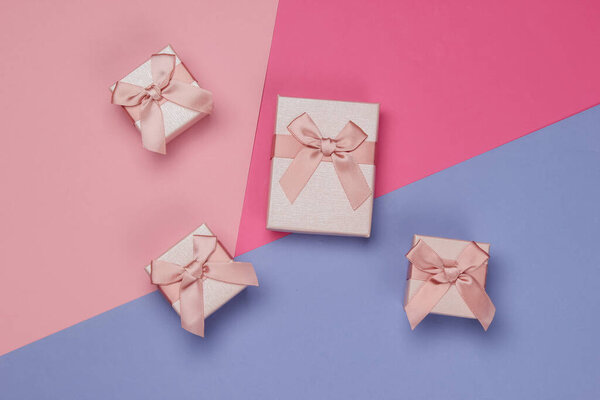 Gift boxes with bows on colored background. Composition for christmas, birthday or wedding. Top view