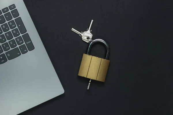 Online security. Internet protection. Password for computer. Laptop and padlock with key on black background.