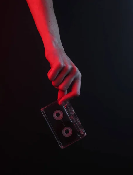 Kobieta Trzyma Kasetę Audio Retro Czarnym Tle Czerwonym Światłem Neonowym — Zdjęcie stockowe