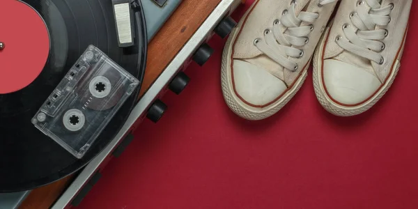 平铺复古媒体和娱乐 乙烯基唱片播放器 盒式磁带 红色背景的运动鞋 复制空间 顶部视图 — 图库照片