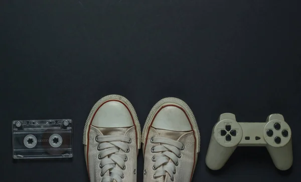 复古旧的运动鞋 录音带和黑色背景的游戏垫 顶部视图 — 图库照片