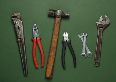 Yeşil arka planda bir takım profesyonel iş aletleri. Üst görünüm.