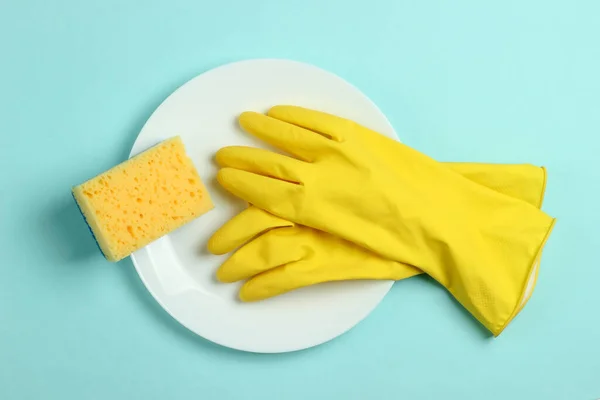 洗碗的概念 用海绵和橡胶手套涂在蓝色粉刷背景上的盘子 顶部视图 — 图库照片