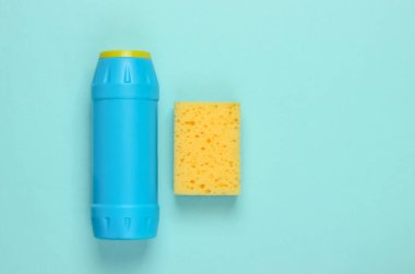 Temizlik için hazır! Ev işi konsepti. Deterjan şişesi, mavi pastel arka planda sünger. Üst görünüm