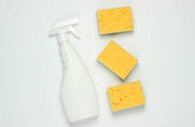 Temizlik için beyaz sprey, beyaz arka planda süngerler. Üst Manzara. Minimalizm