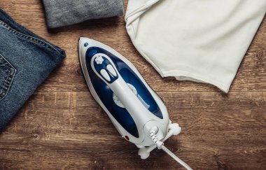 Ütü için ütü, yerde giysiler. Ev hayatı konsepti. Üst görünüm