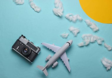 Uçak, bulutlar, güneş ve kamerayla seyahat konseptinin düz dizaynı. Minimalizm. Üst görünüm