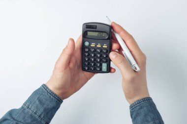 Beyaz arkaplandaki bir hesap makinesinde erkek eller sayılıyor